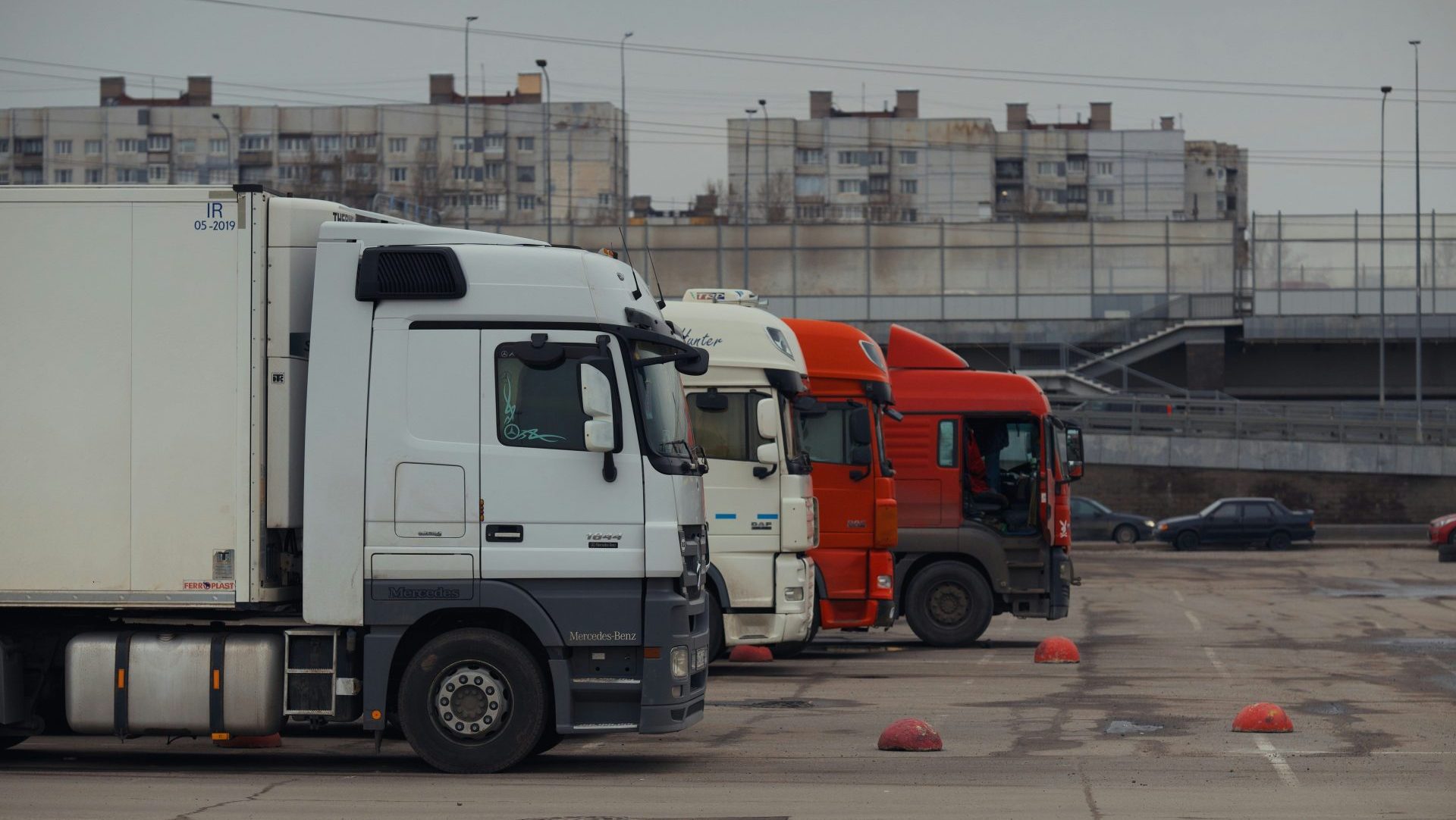 Trucks are parked in a row in a parking lot.